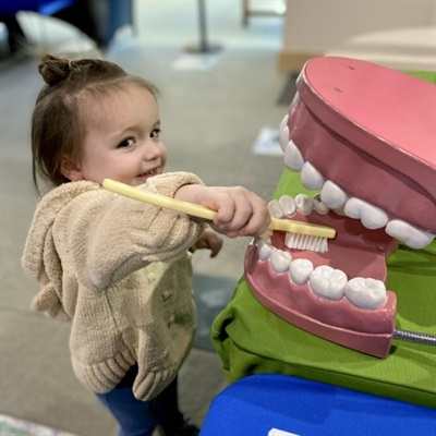 Enroll Online or In-Person Child brushing big teeth